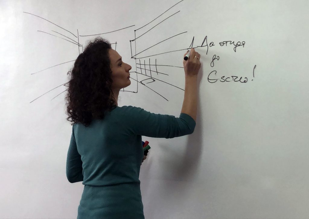 Woman writing on a dry erase wall